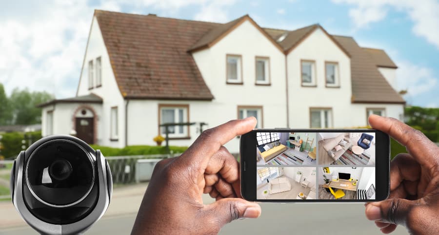 Man holding smartphone and looking at footage from surveillance cameras